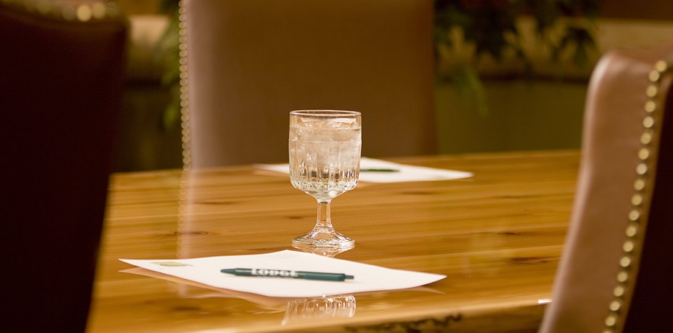 Table with paper, pen, and a glass of water
